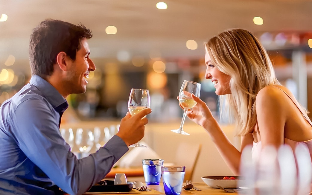 Couple toasting with wine on Starlight Dinner Cruise in Sydney.