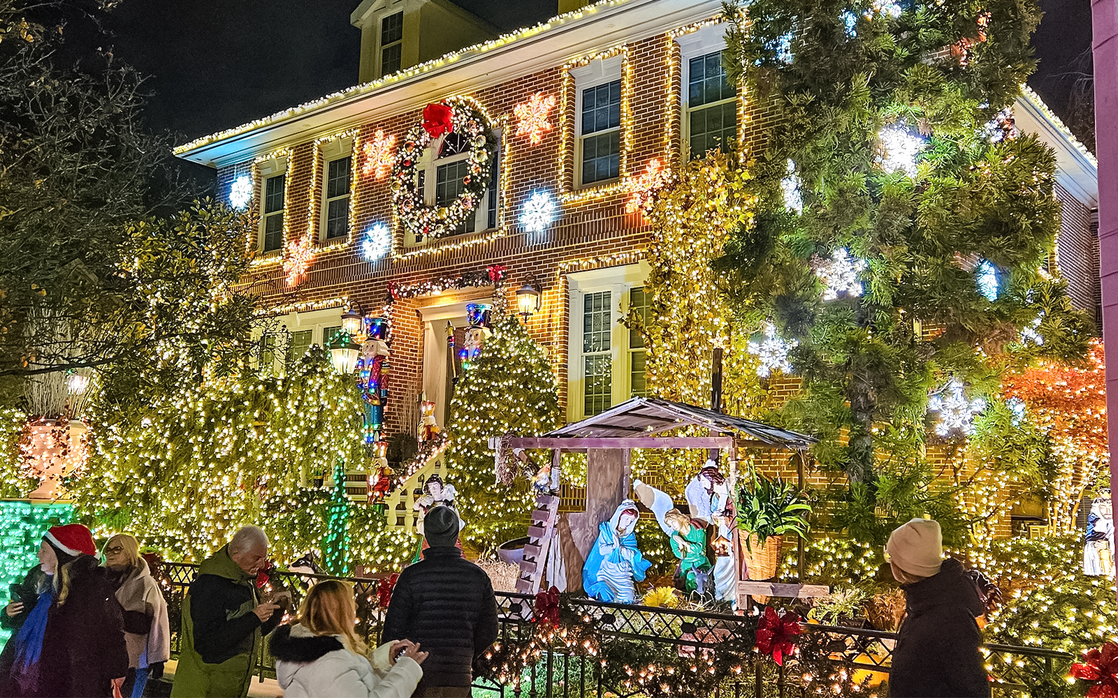 New York house adorned with Christmas lights and nativity scene during holiday bus tour.