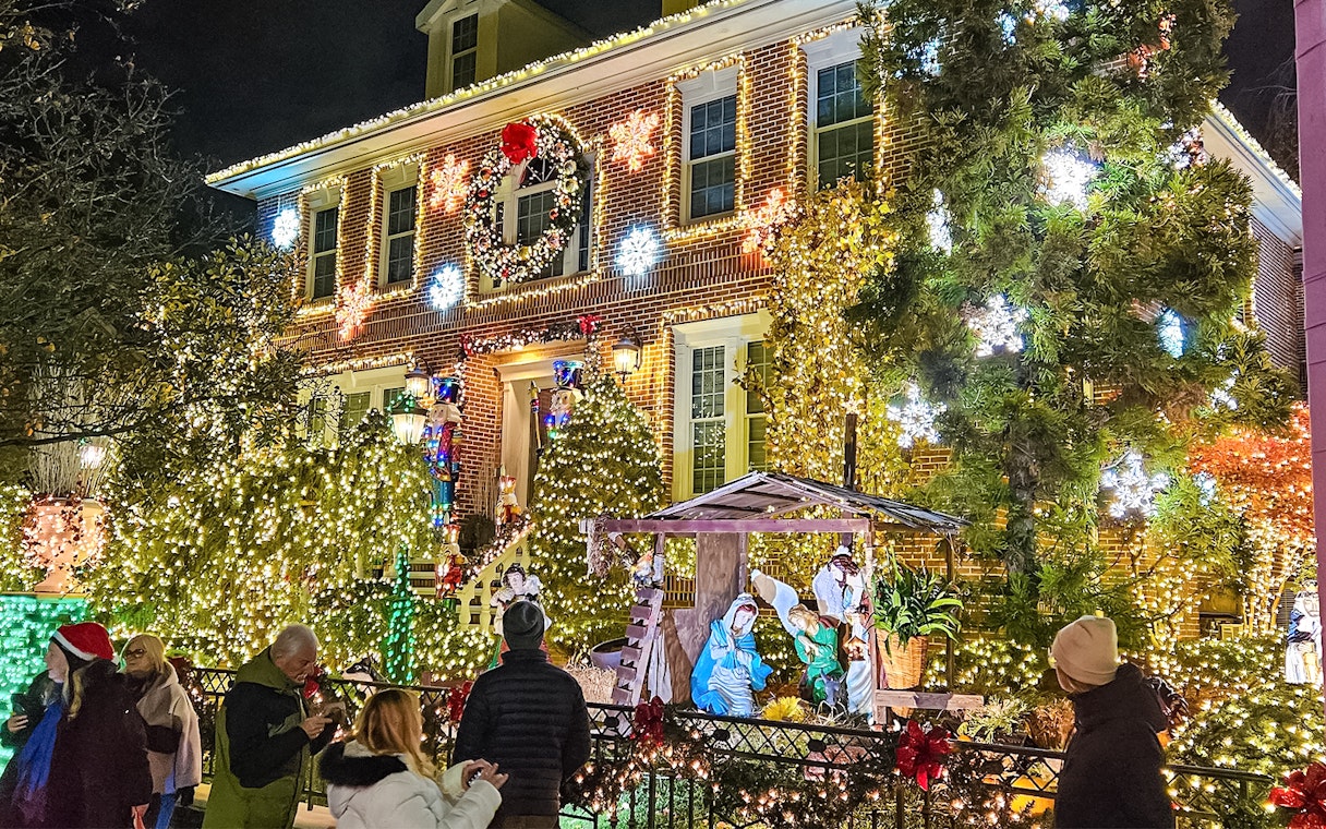 New York house adorned with Christmas lights and nativity scene during holiday bus tour.