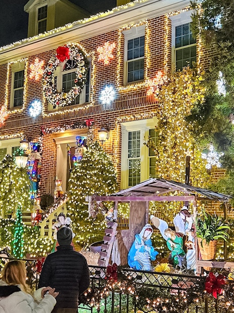 New York house adorned with Christmas lights and nativity scene during holiday bus tour.
