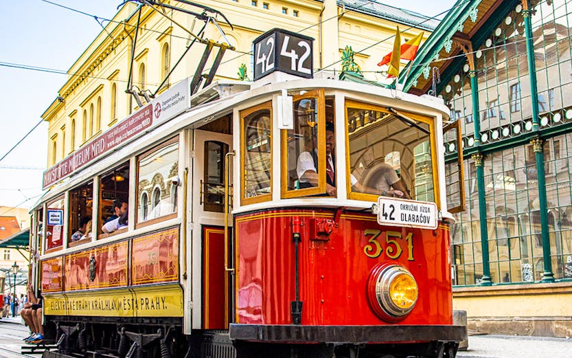 Prague historical tram on Line 42 passing through city streets, part of 24-hour hop-on hop-off tour.