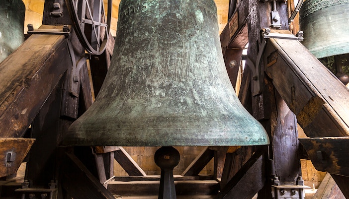 Large church bell in Florence, Italy, highlighting intricate engravings and historical significance.