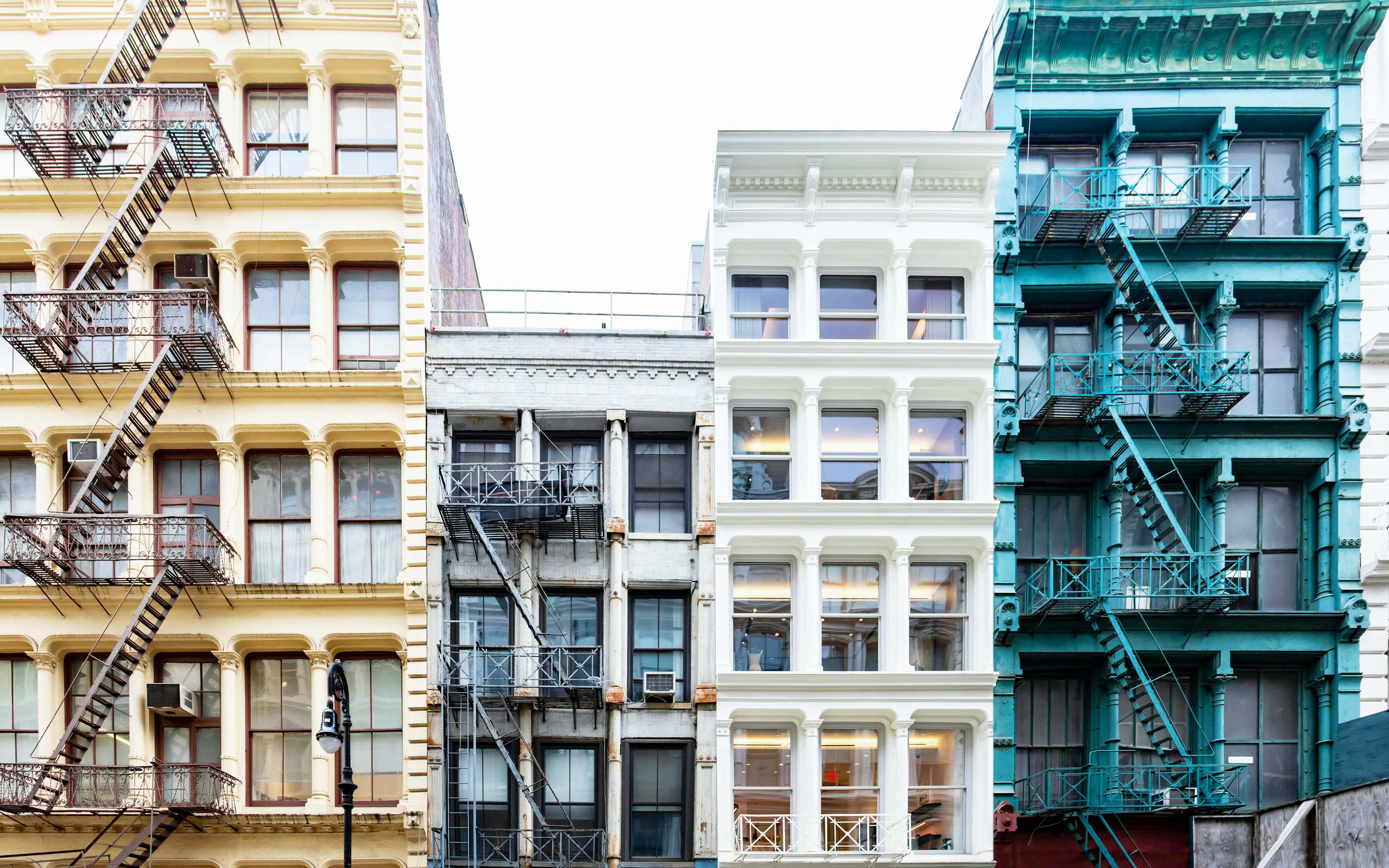 Colorful historic buildings with fire escapes on Greene Street, SoHo, New York City.
