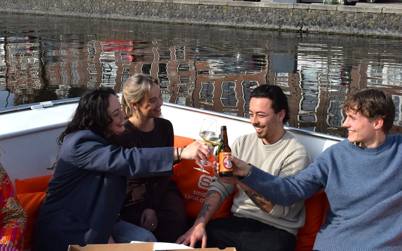 Guests enjoying drinks on a Haarlem canal cruise with Nolita pizza.