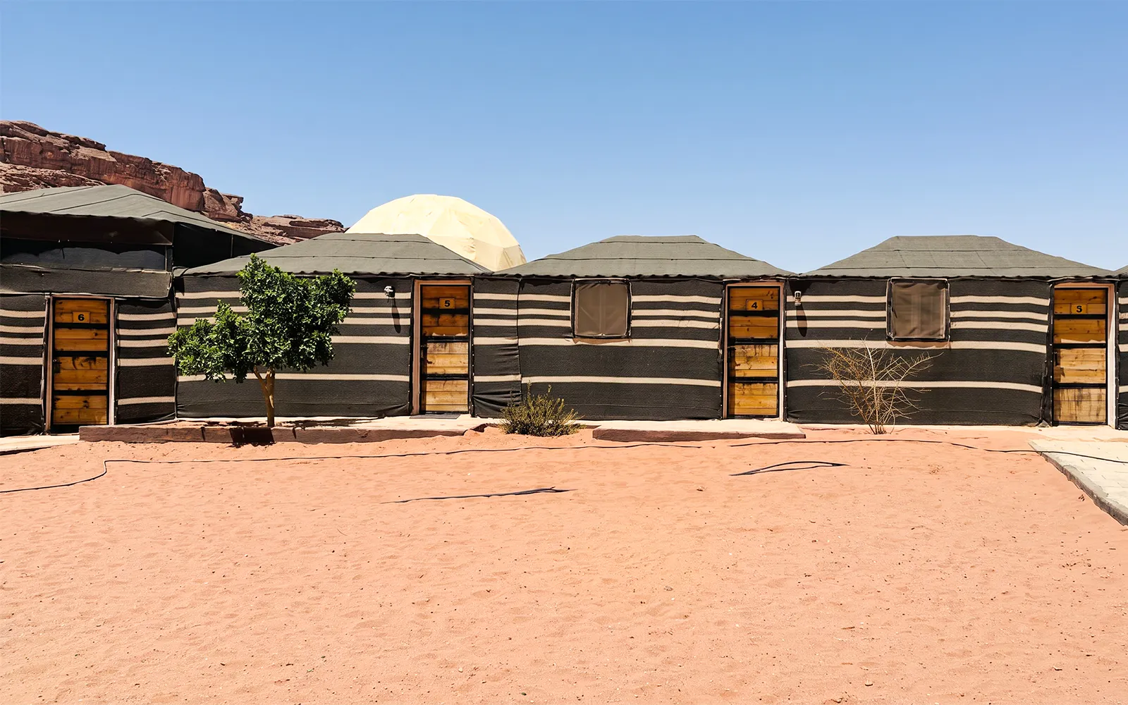 Desert camp huts in Wadi Rum, part of a 2-day tour from Amman to Petra, Wadi Rum, and Dead Sea.