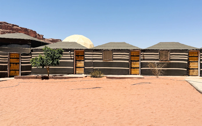 Desert camp huts in Wadi Rum, part of a 2-day tour from Amman to Petra, Wadi Rum, and Dead Sea.