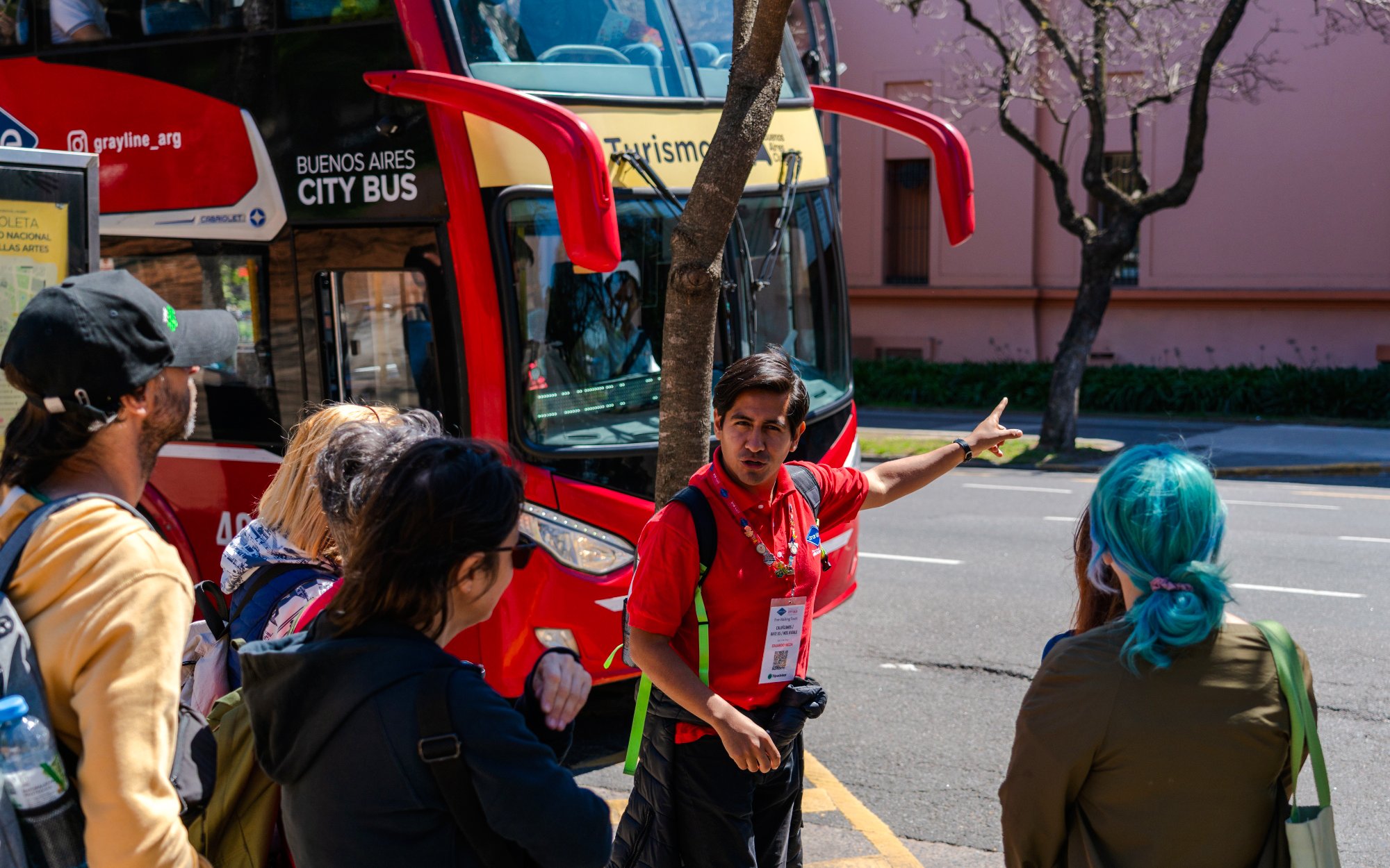 Guide explaining to tourists near Buenos Aires hop-on hop-off bus.