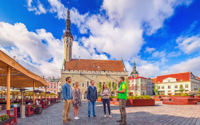 Tour group at Raekoja Plats with Tallinn Old Town Hall in background, Estonia.