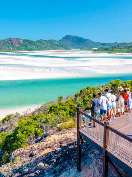 Tourists on a lookout deck viewing Whitehaven Beach's turquoise waters and sandbars, Whitsundays.