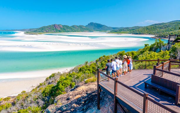 Tourists on a lookout deck viewing Whitehaven Beach's turquoise waters and sandbars, Whitsundays.