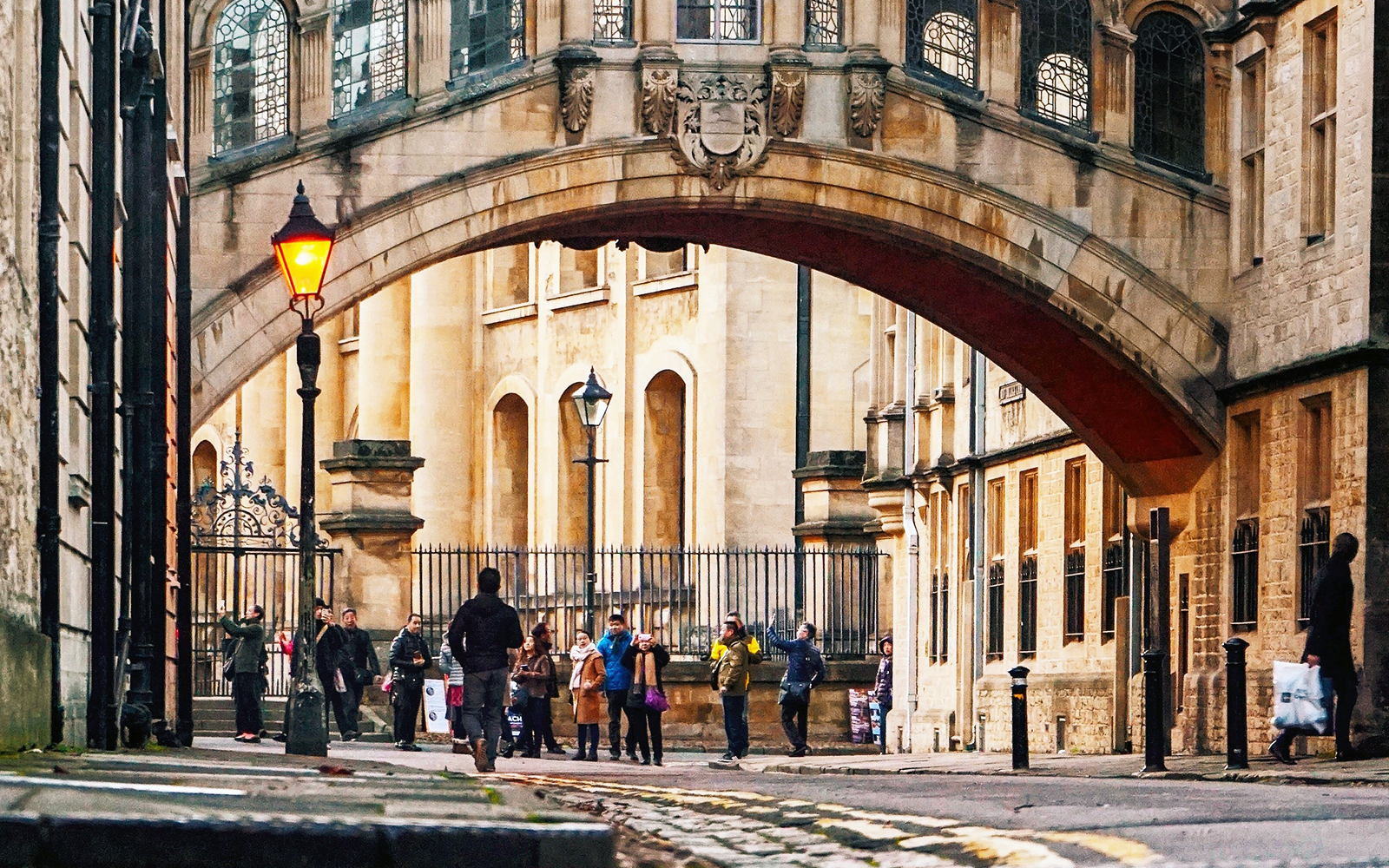 Group of tourists under the Bridge of Sighs in Oxford during a guided tour.