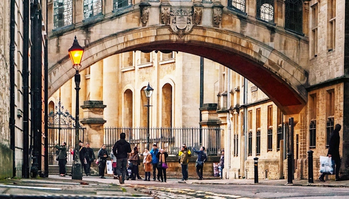 Group of tourists under the Bridge of Sighs in Oxford during a guided tour.