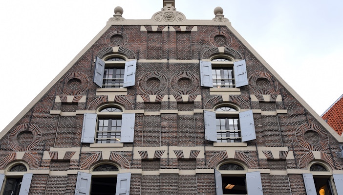 Amsterdam Jewish Cultural Quarter synagogue interior with ornate chandeliers and wooden pews.