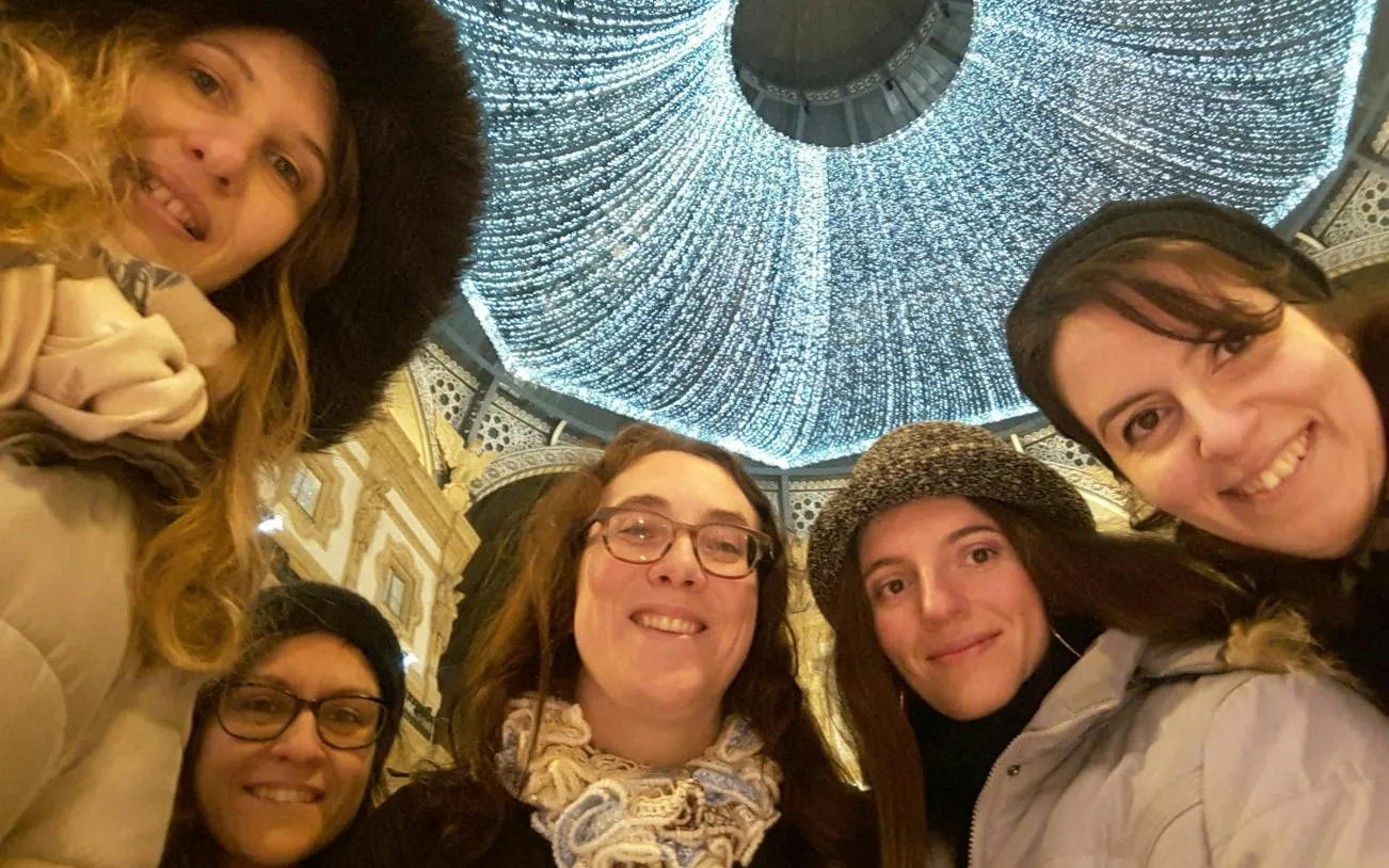Visitors under festive lights at Galleria Vittorio Emanuele II, Milan during Christmas.