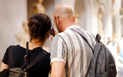 Guests using audio guide in museum hallway.