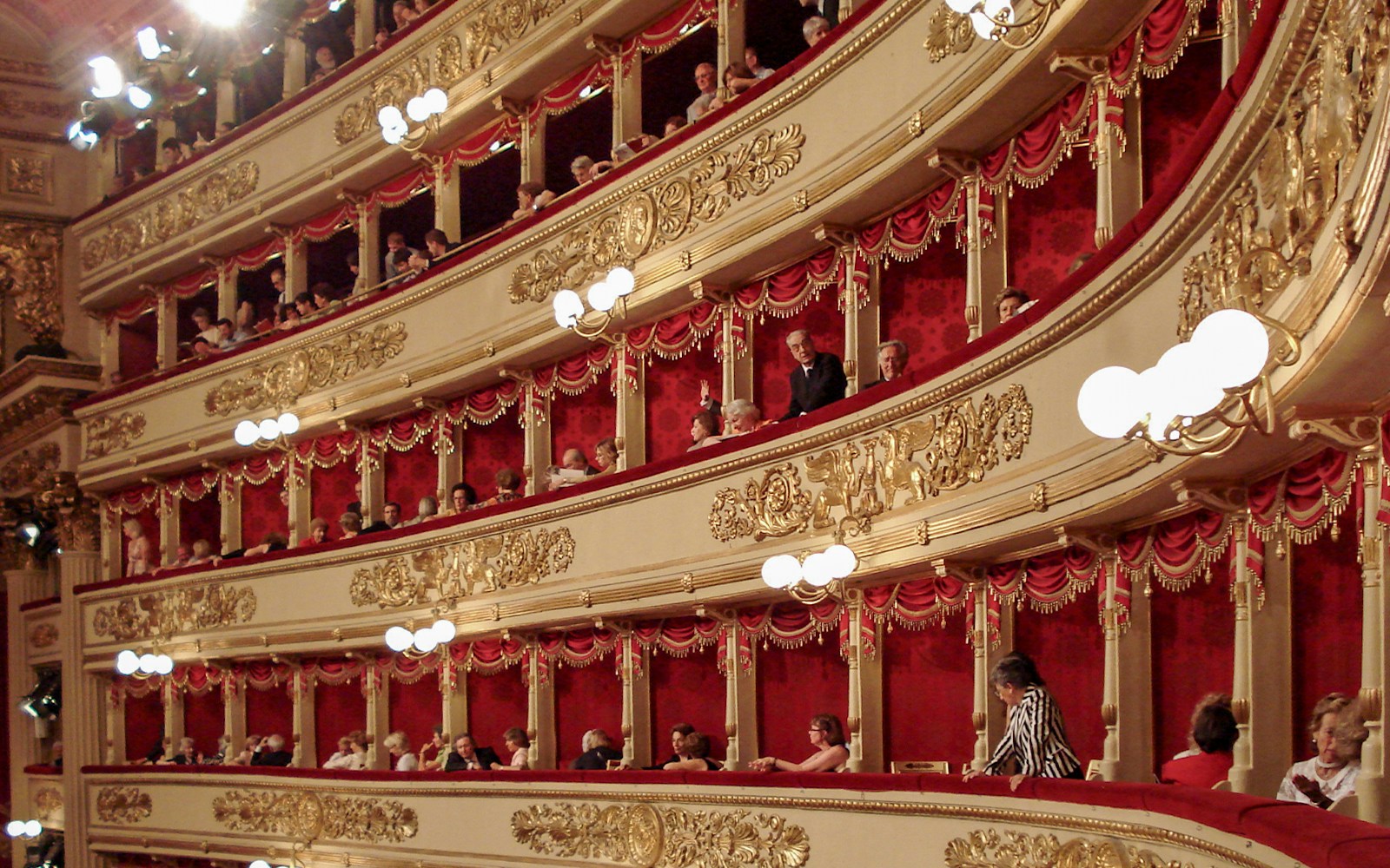 Teatro alla Scala Milan exterior with ornate architecture and people entering the historic opera house.