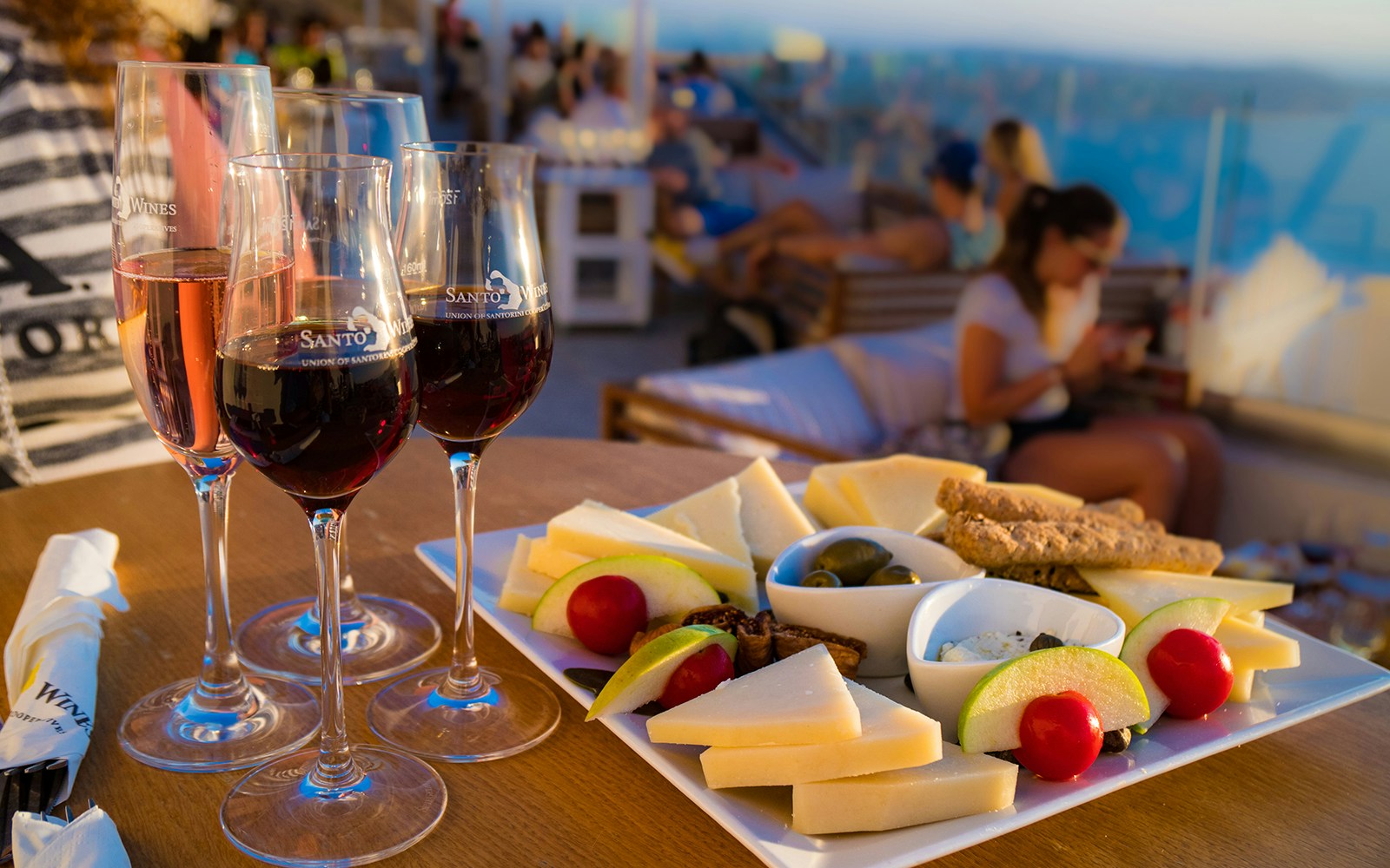 Wine glasses and cheese platter at a Santorini terrace during a guided tour with wine tasting.