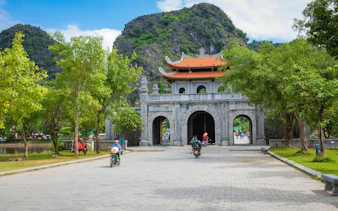 Temple of Dinh Tien Hoang entrance at Hoa Lu, Ninh Binh, with limestone mountains in the background.