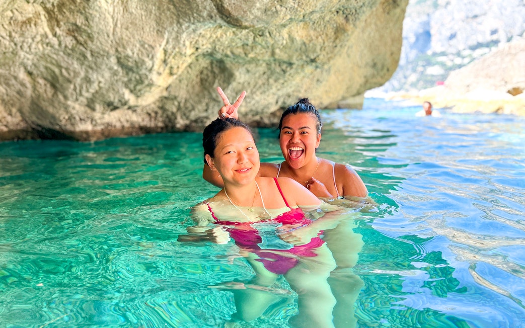 Kayakers enjoying clear waters in a cave during a Capri tour.