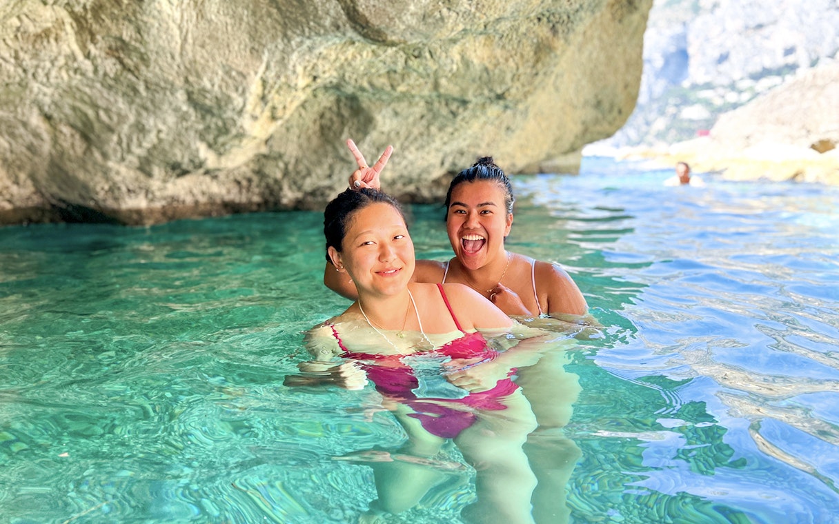 Kayakers enjoying clear waters in a cave during a Capri tour.