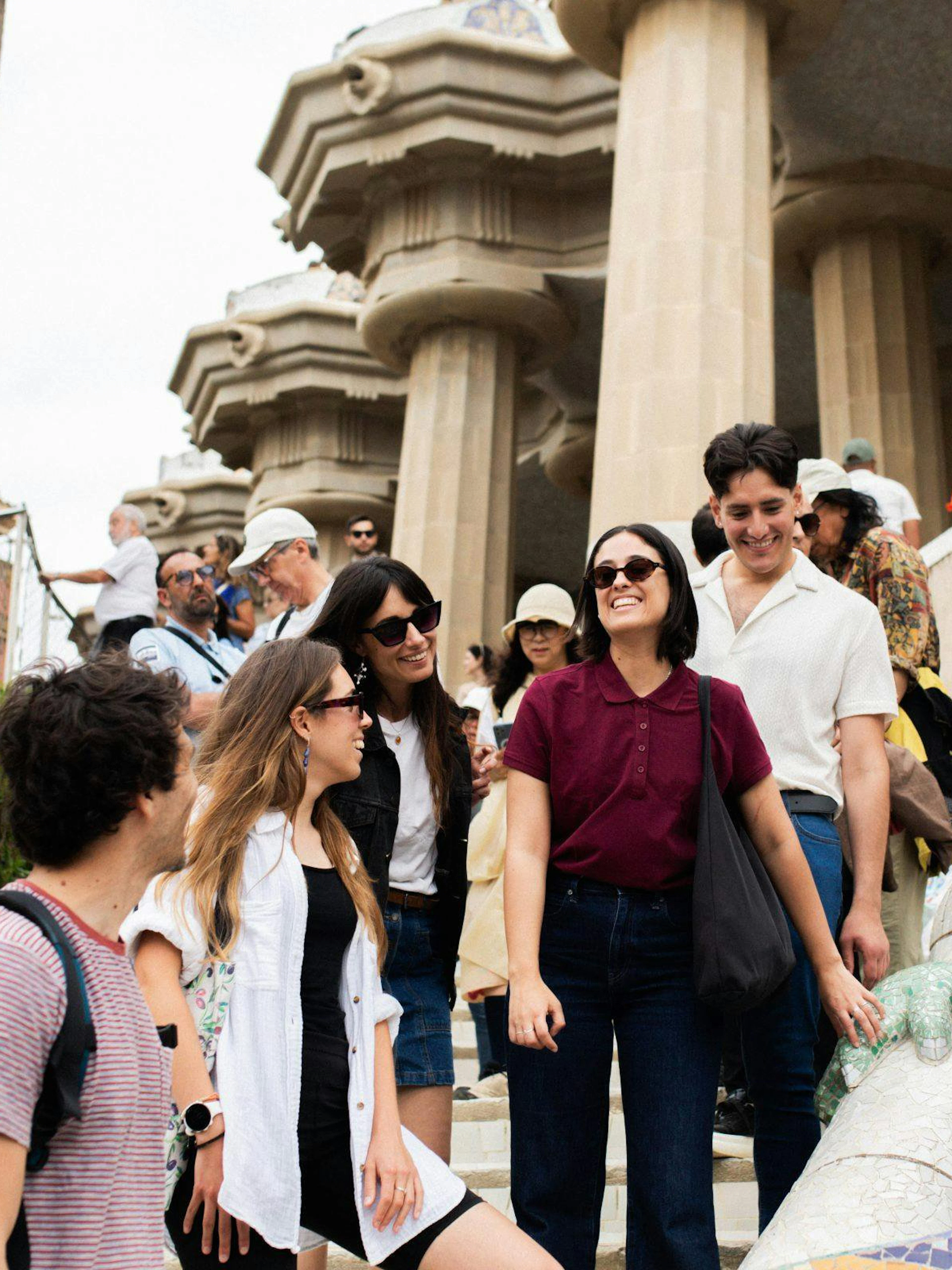 Tourists with guide at Park Güell near mosaic lizard sculpture, Barcelona.