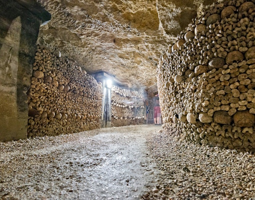 Pathway lined with skulls and bones in the Paris Catacombs.