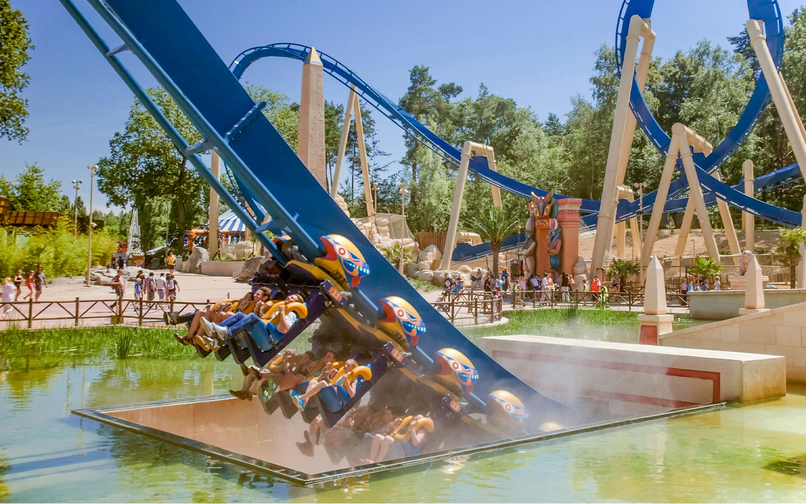 Roller coaster ride at Parc Asterix with passengers descending near water.