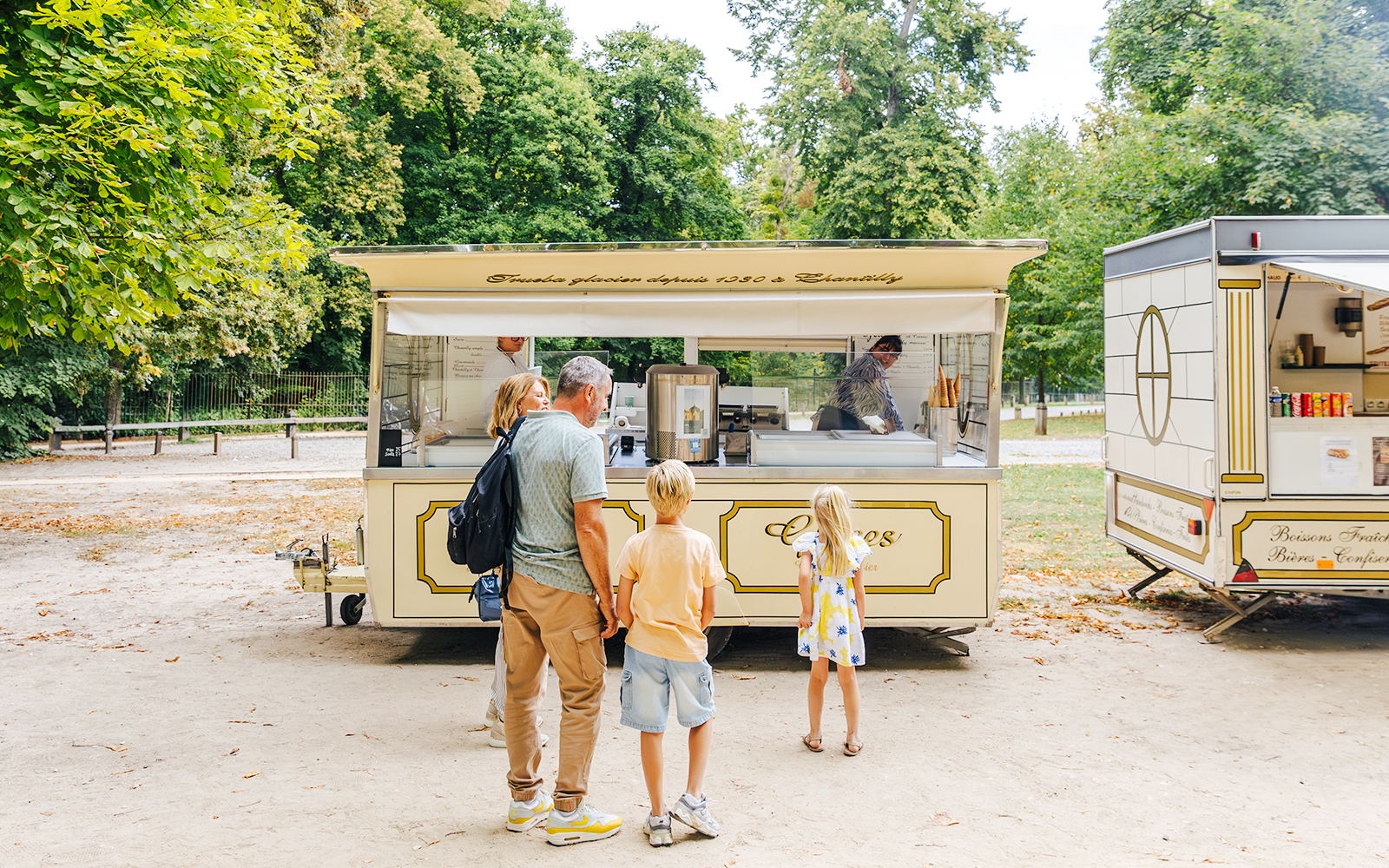 Family at an ice cream stand in the gardens of Chateau of Chantilly.