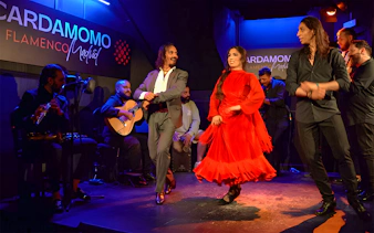 Flamenco dancers performing at Cardamomo in Madrid with musicians on stage.