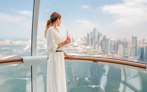 Visitor enjoying city skyline view from inside Ain Dubai.