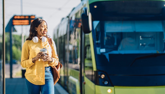 Tourists waiting at a bus stop in London for a city sightseeing tour.