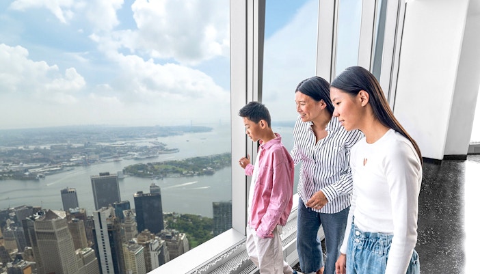 Tourists enjoying New York skyline view from One World Observatory with deluxe skip-all-lines ticket.
