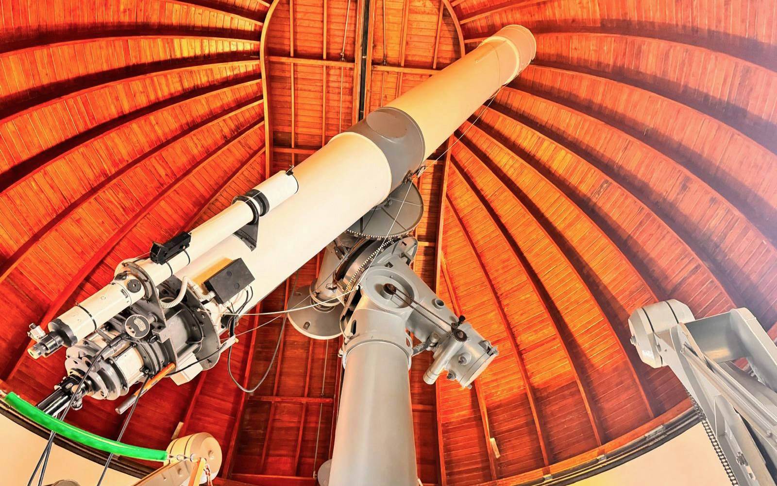 Telescope inside the Castle Gandolfo Observatory with wooden dome ceiling.