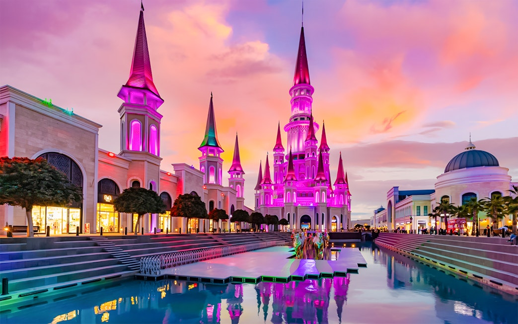 The Land of Legends theme park illuminated at sunset with vibrant colors.