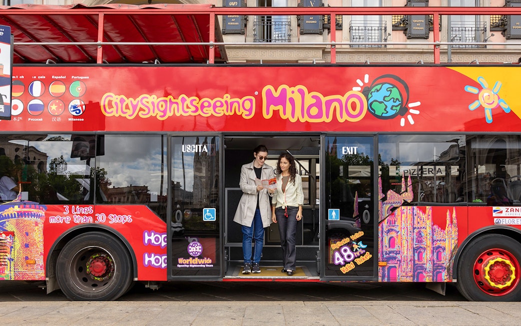 Passengers exiting City Sightseeing hop-on hop-off bus in Milan.