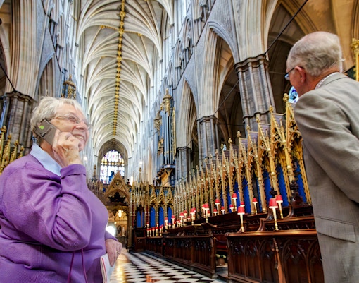 Visitors inside Westminster Abbey during a guided tour, admiring the ornate architecture.