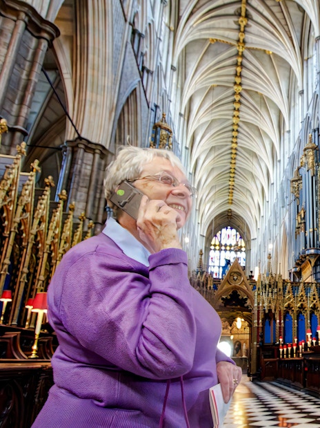 Visitors inside Westminster Abbey during a guided tour, admiring the ornate architecture.