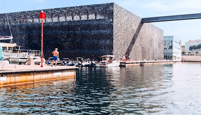 Boats docked near Mucem museum in Marseille during a boat tour experience.