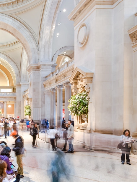 Grand entrance hall of the Metropolitan Museum of Art with visitors exploring.