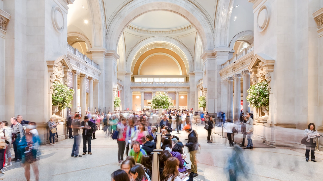 Grand entrance hall of the Metropolitan Museum of Art, showcasing architectural details and visitors.