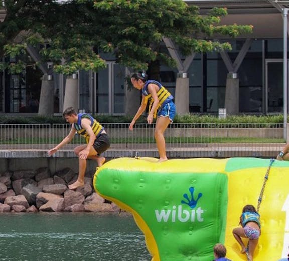 Visitors enjoying inflatable obstacle course at Darwin Aqua Park.