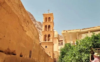 St. Catherine Monastery bell tower with Mount Sinai backdrop on a sunny day.