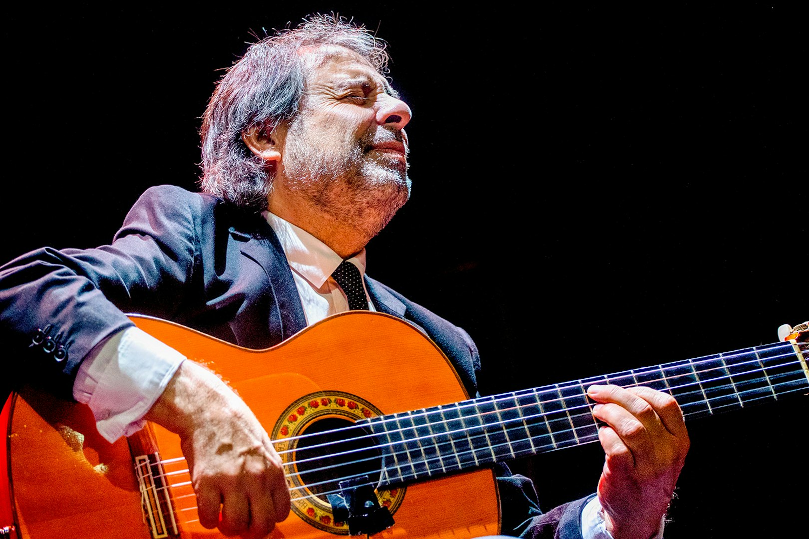 Flamenco guitarist performing at Esencia espectáculo flamenco.