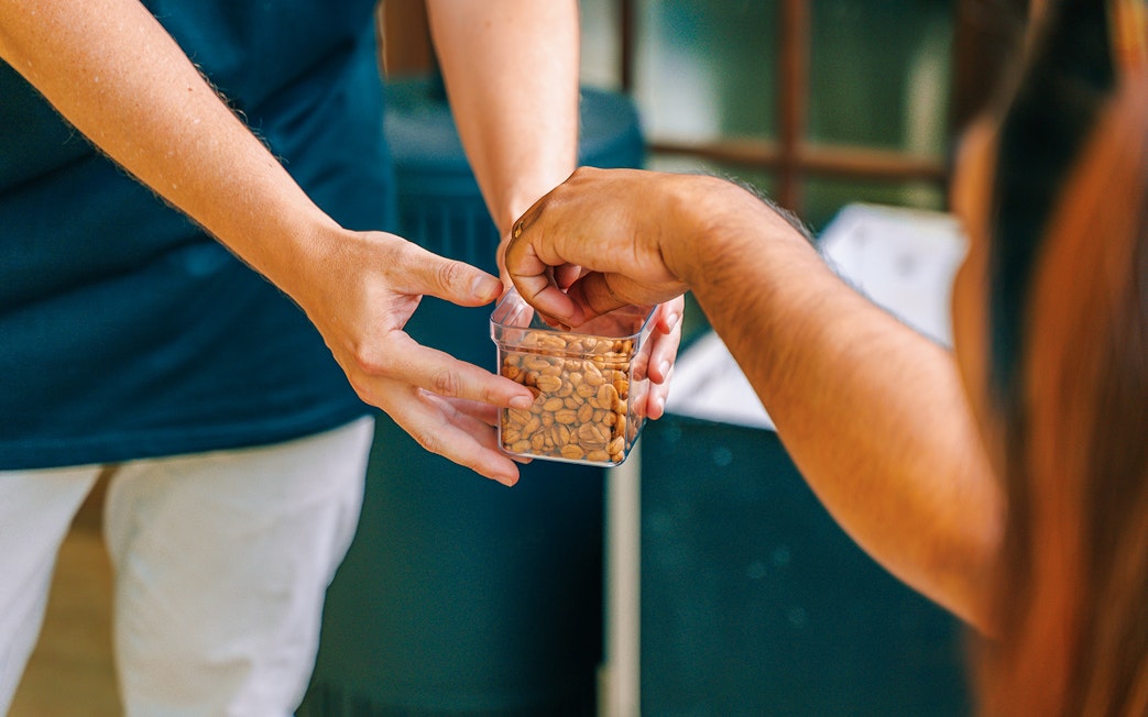 Hands exchanging a container of nuts during The Tastes of Tamborine Mountain tour.
