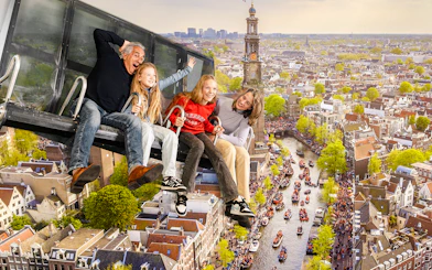 Tourists enjoying 5D ride at This Is Holland with aerial view of Amsterdam canal.