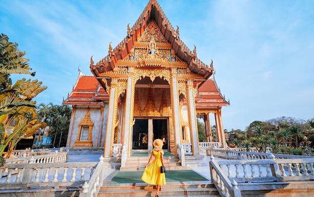 Woman approaching ornate temple entrance in Phuket.