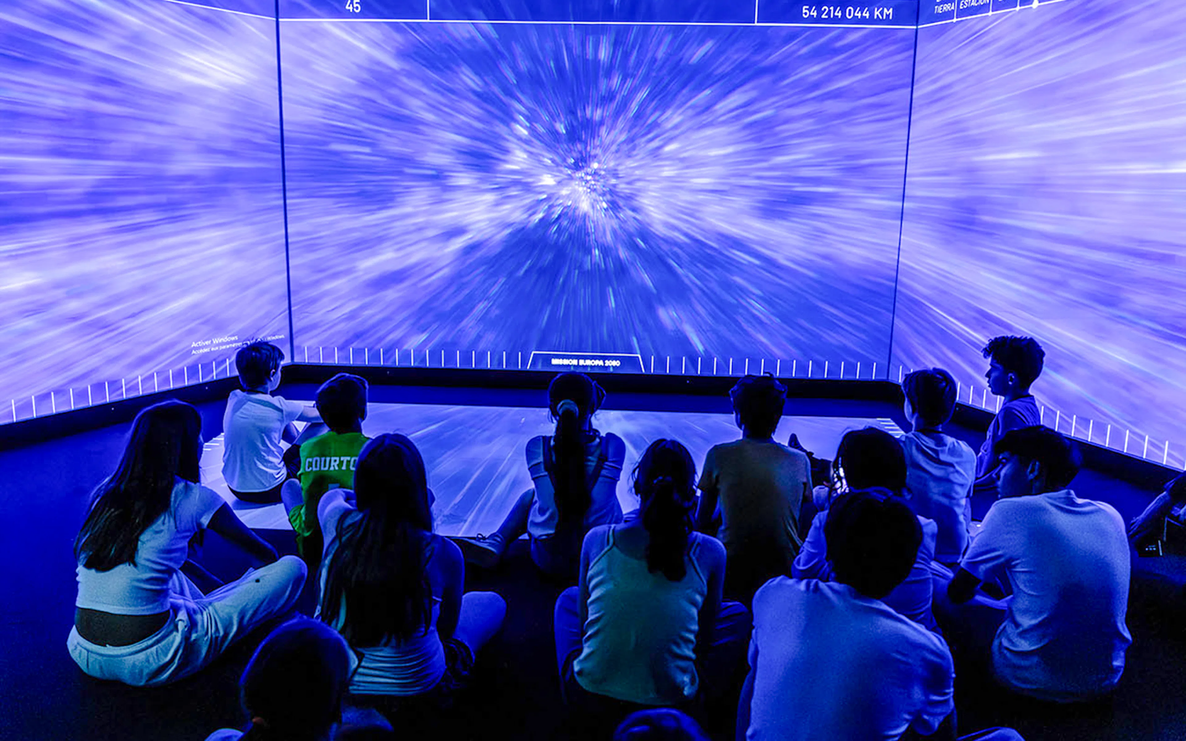 Visitors watching immersive space exhibit at Science & Industry Museum, Paris.