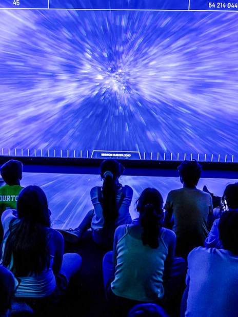 Visitors watching immersive space exhibit at Science & Industry Museum, Paris.
