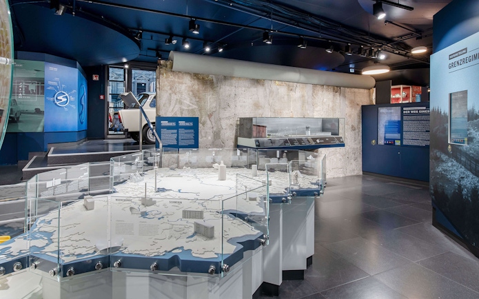 DDR Museum Berlin exhibit with Trabant car and Berlin Wall display.