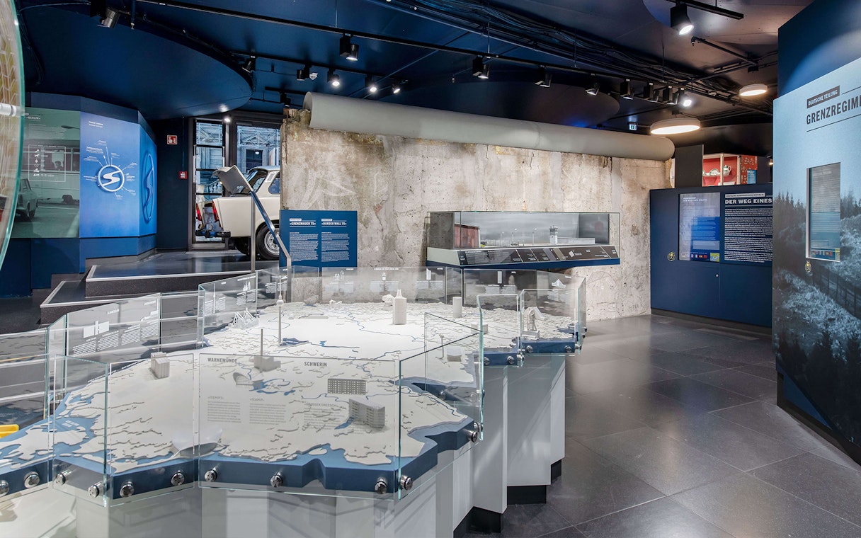 DDR Museum Berlin exhibit with Trabant car and Berlin Wall display.